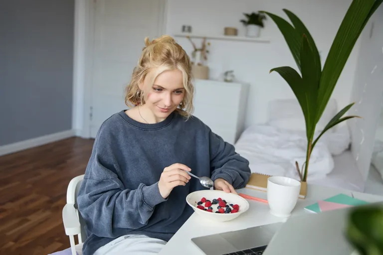 Girl watching videos on a lap and eating