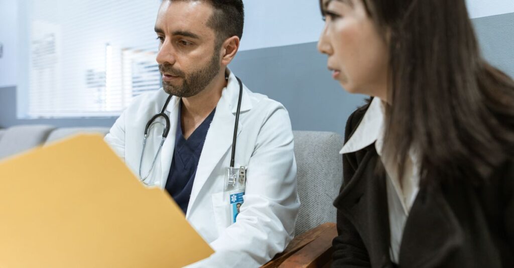 Doctor discusses health records with a patient in a clinical setting. — gyno in men