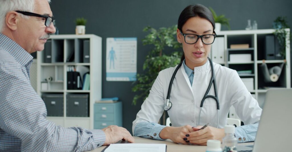 Medical professional discusses health with senior man in modern office setting. — pituitary gland tumors can secrete excess a