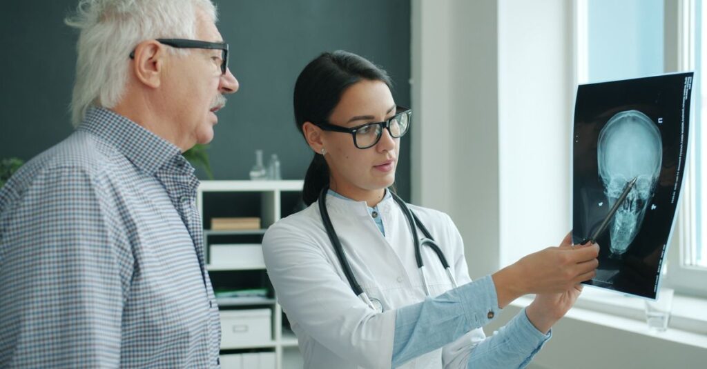 A doctor reviews a patient's head X-ray in a medical office, discussing the results. — average testosterone in men