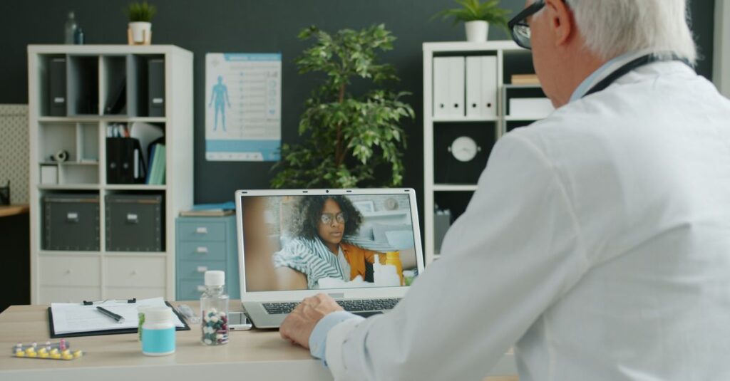 A doctor conducts a virtual consultation with a patient on a laptop in a modern office. — weight loss metabolic syndrome