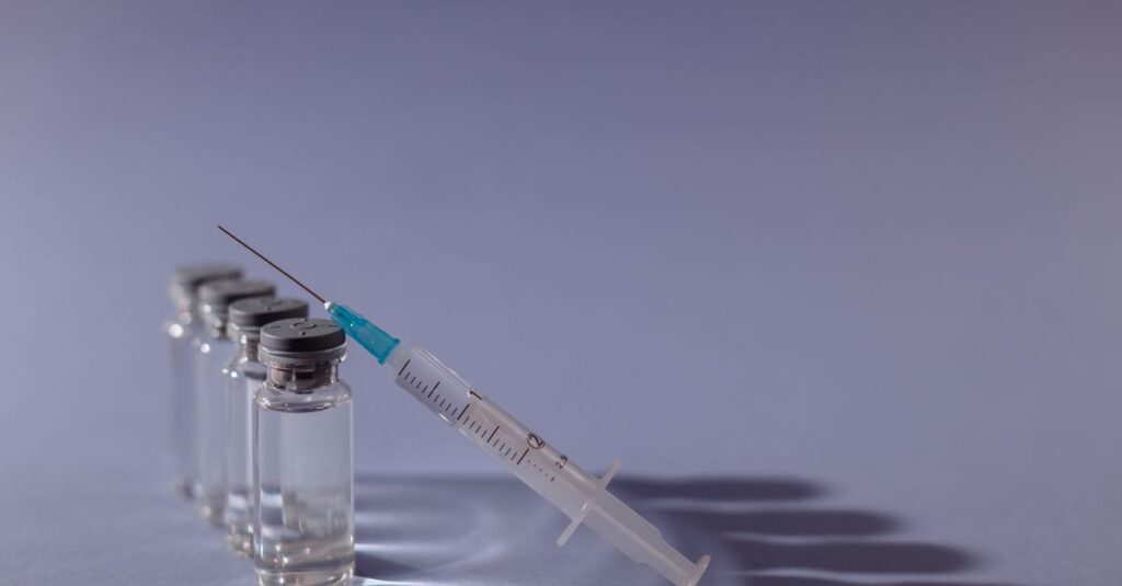 Syringe and vaccine vials arranged on gray surface, symbolizing healthcare and immunization. — semaglutide dosage chart